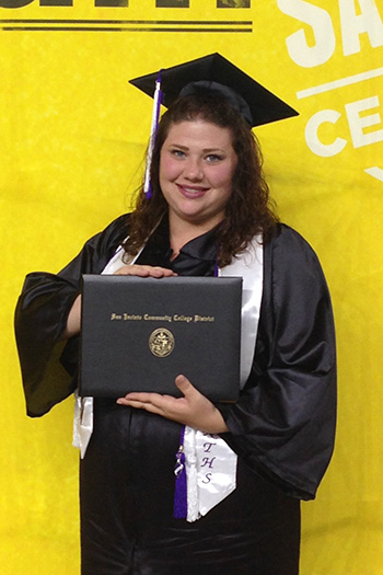Tabitha Godinez in cap and gown holding college diploma